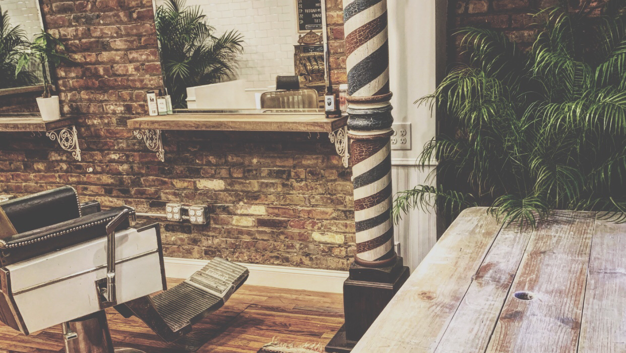 Brick wall, barber pole and chair inside the Wythe Avenue shop